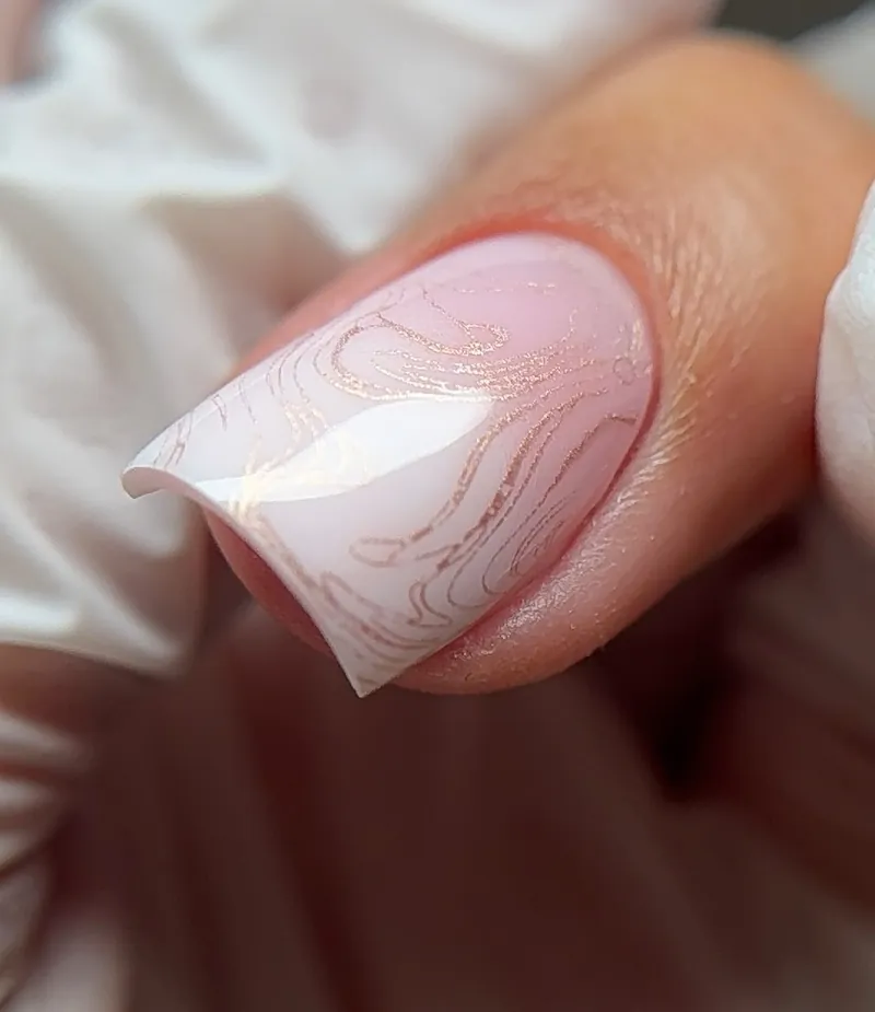 Ongle carré rose lacté avec un motif marbré en feuille d'or.